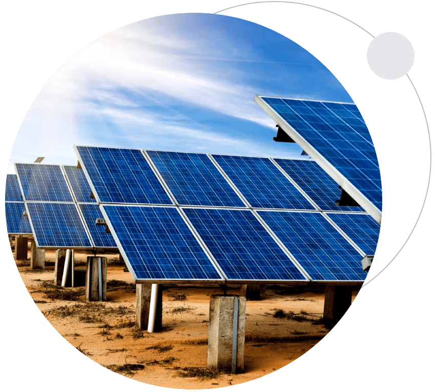 A group of solar panels sitting on top of a dirt field.