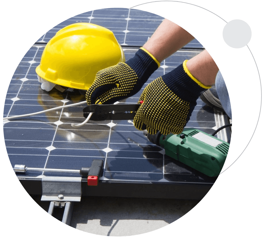 A person with gloves and hard hat working on solar panels.